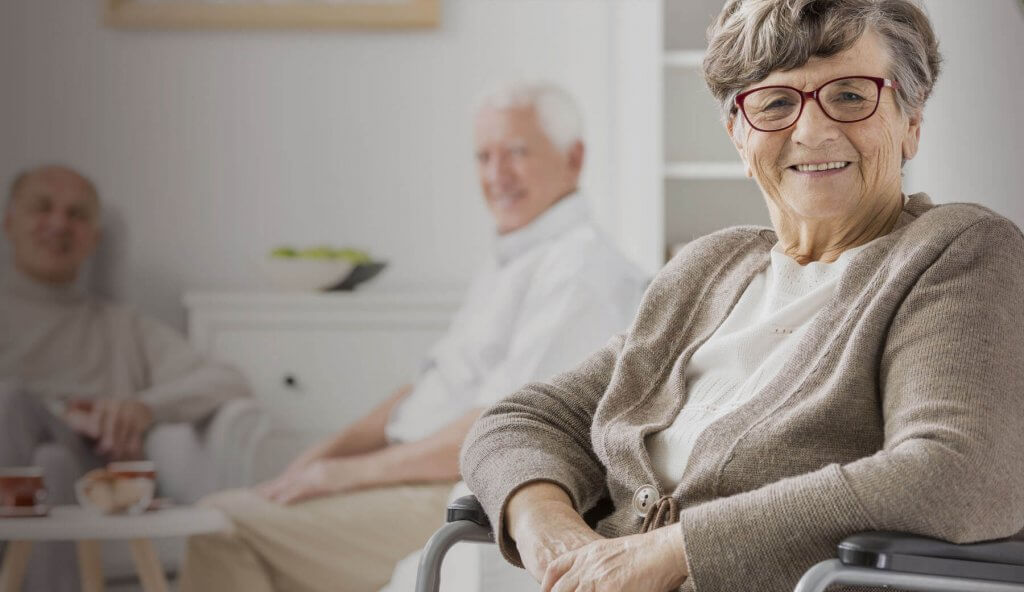 Old lady with glasses in wheelchair smiling